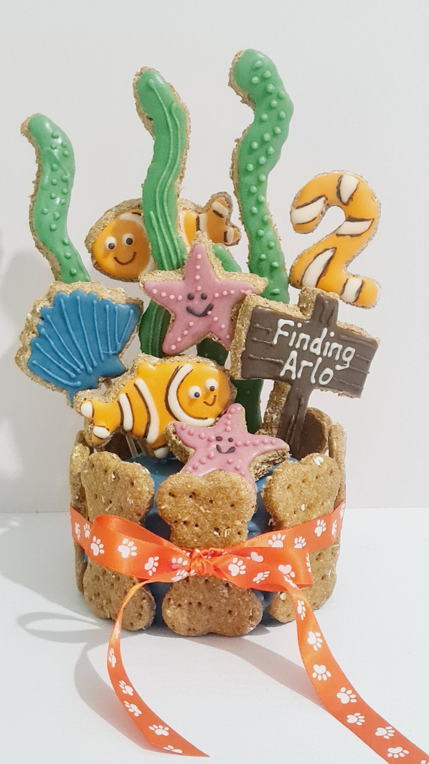 Dog treats shaped like sea creatures with a ribbon on a white background