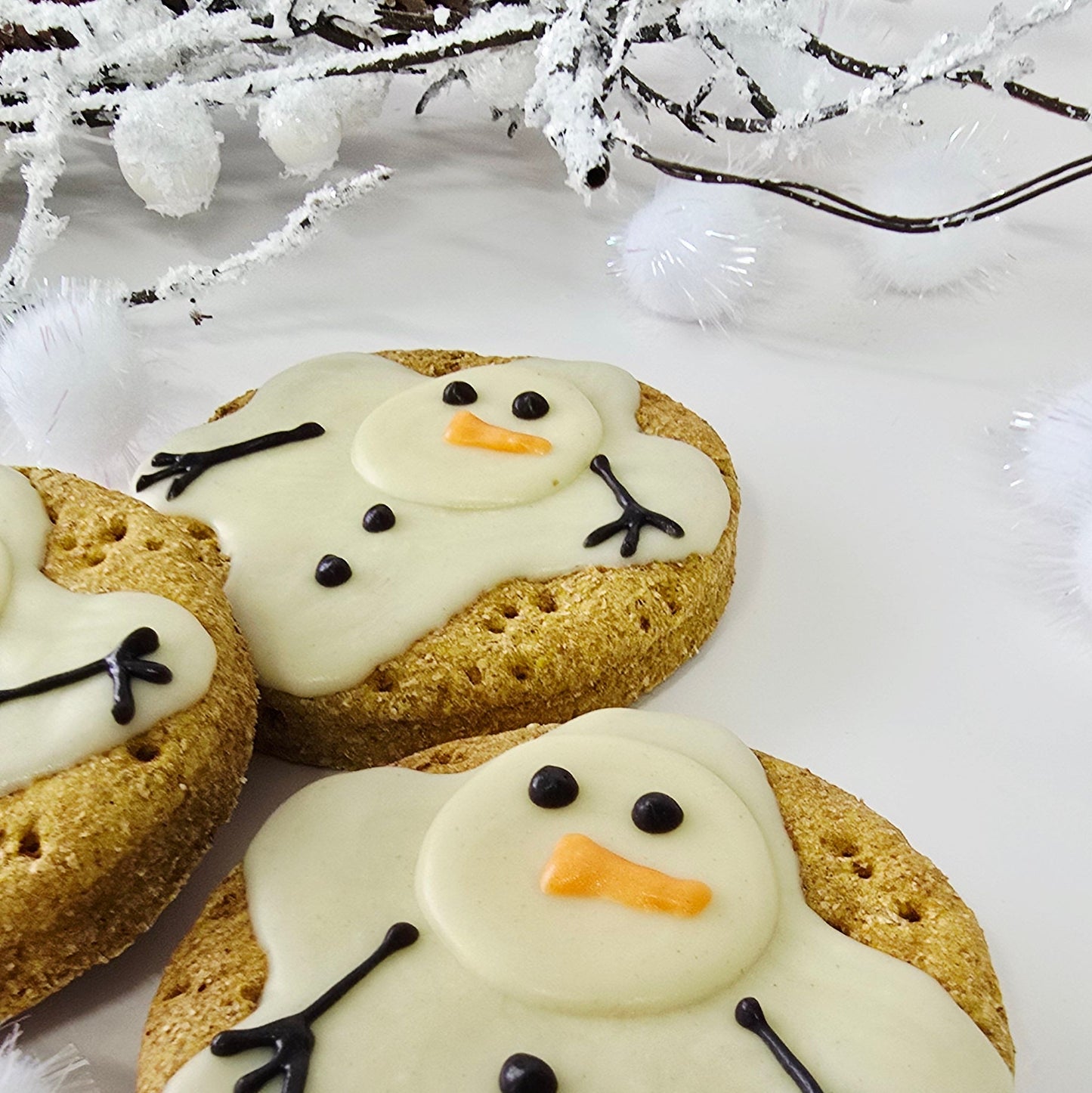 Cookies decorated like snowmen on a white background