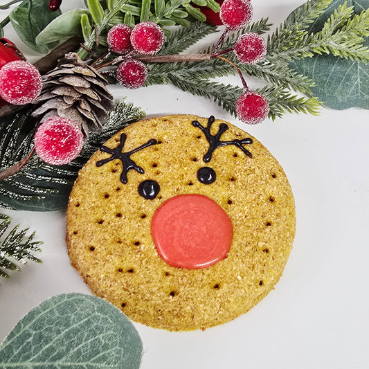 Decorative wreath with a reindeer cookie and greenery on a white background