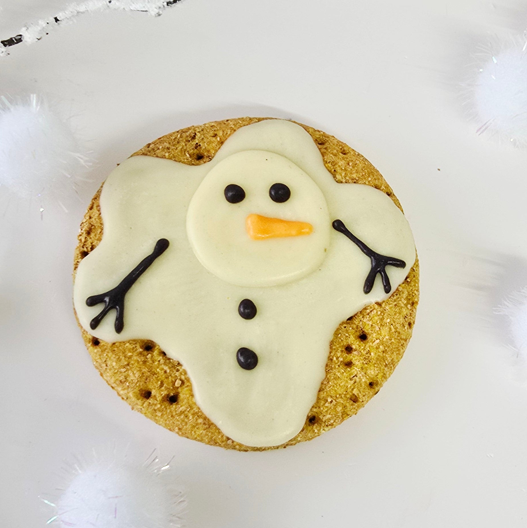 Cookie decorated like a snowman on a white background