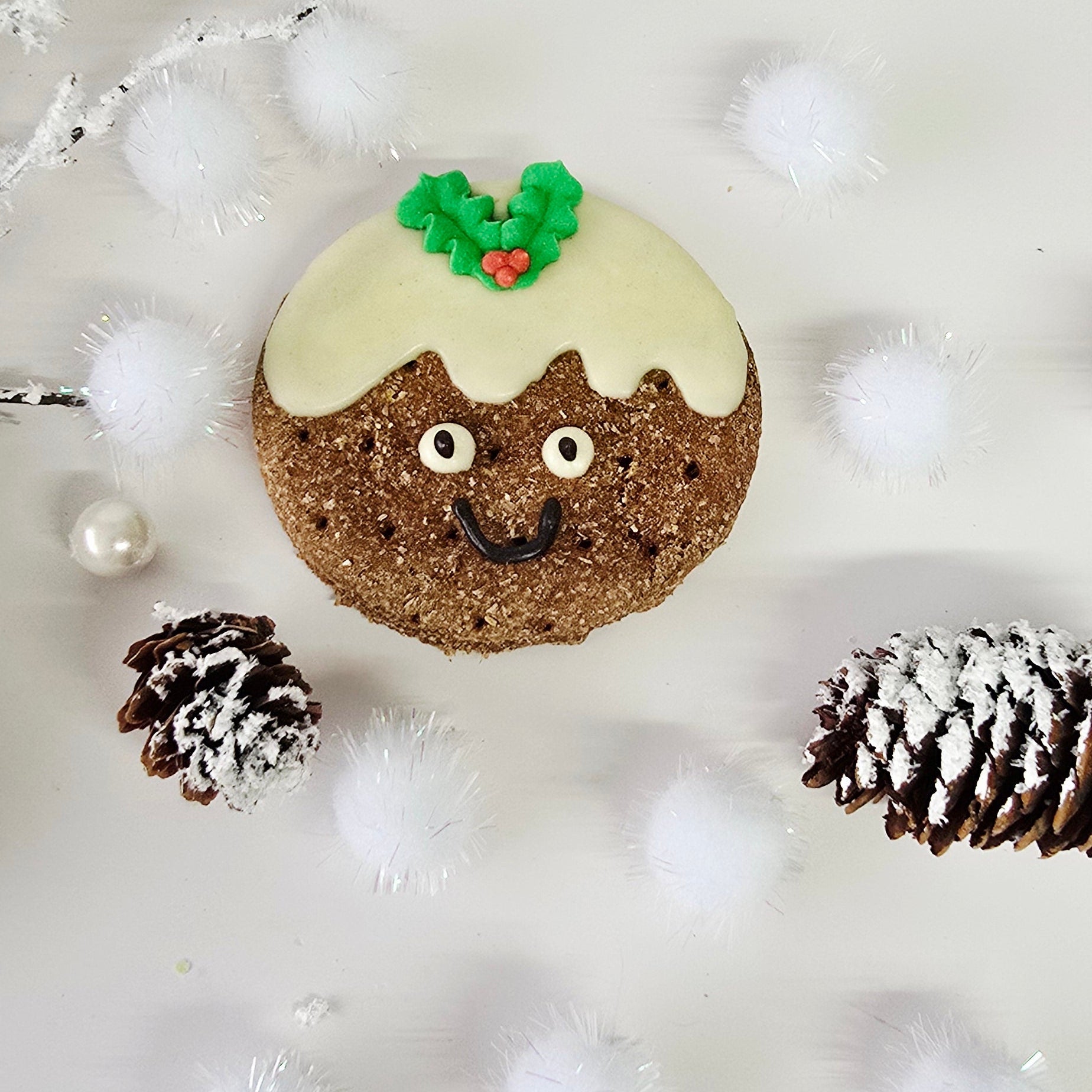 Decorative stone with a Christmas design on a light background with pine cones and branches.